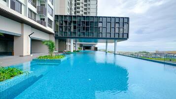 A modern swimming pool with a clear view of the ocean in the background.