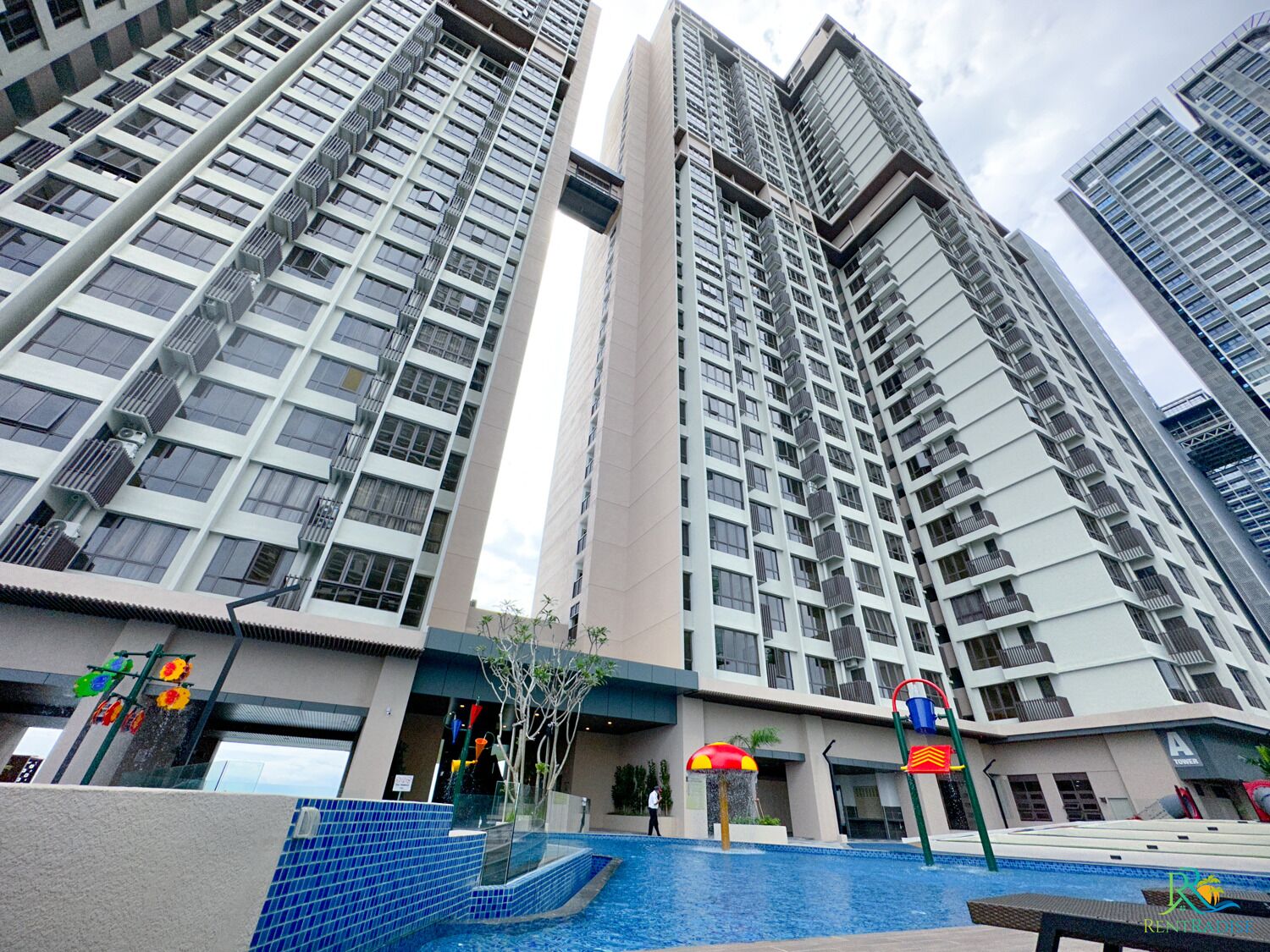 Um edifício residencial alto com várias varandas, área de piscina e um estabelecimento comercial no andar térreo.