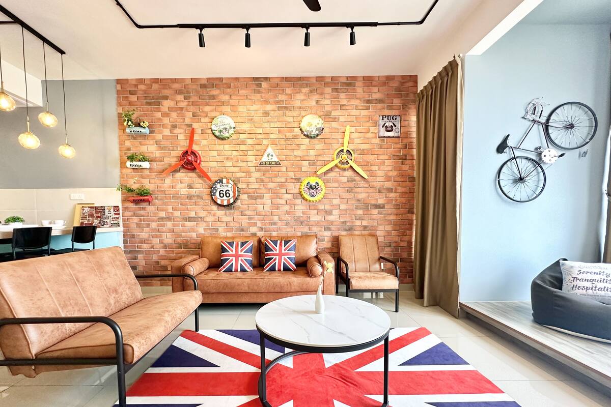 Un salon moderne avec un mur en briques, un canapé, une table basse et un coin repas.