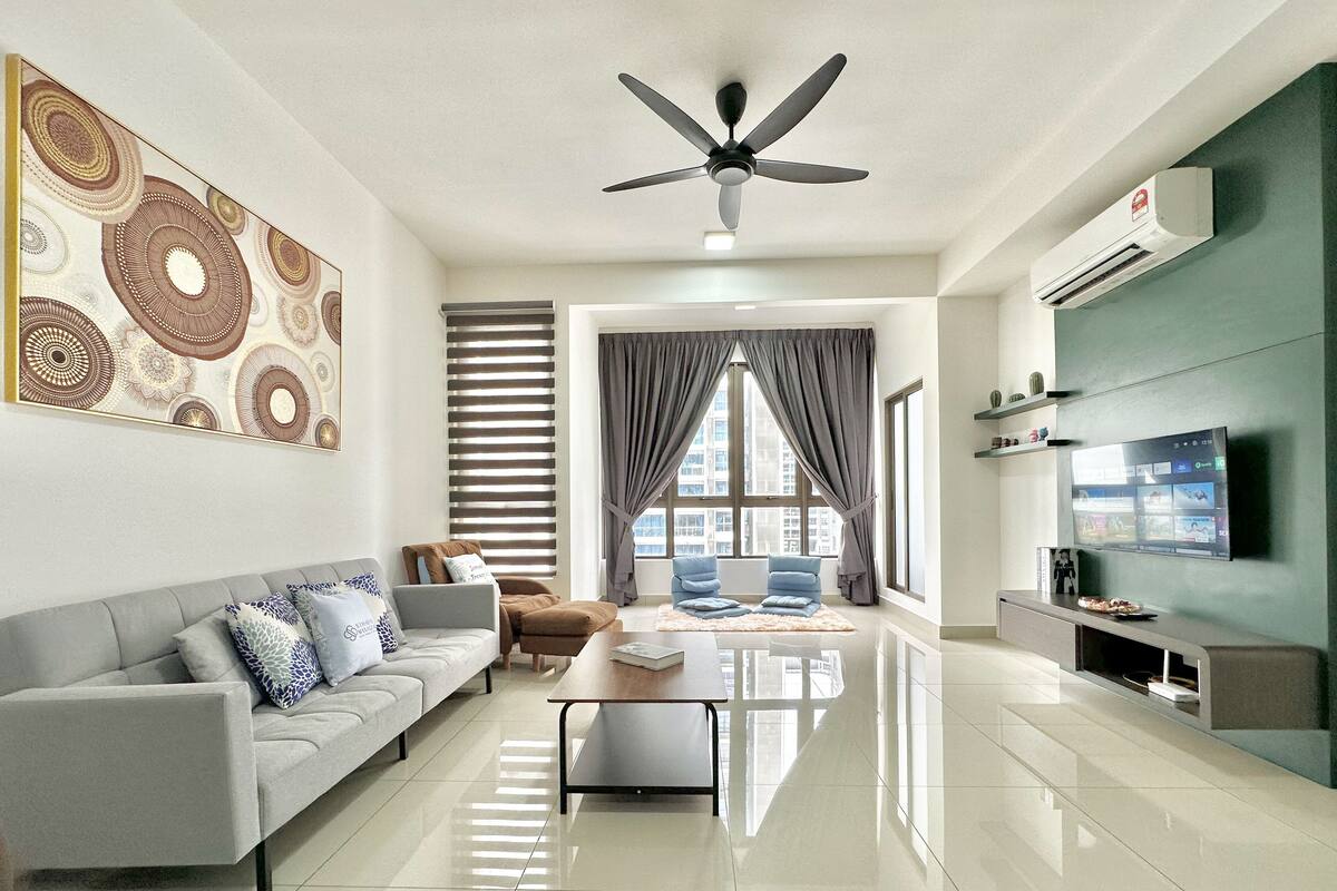 Un salon moderne avec un canapé gris, une table basse et un ventilateur de plafond.