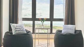 Suite estudio, vista a la ciudad | Área de sala de estar | Smart TV de 58 pulgadas con canales digitales, televisión y Netflix