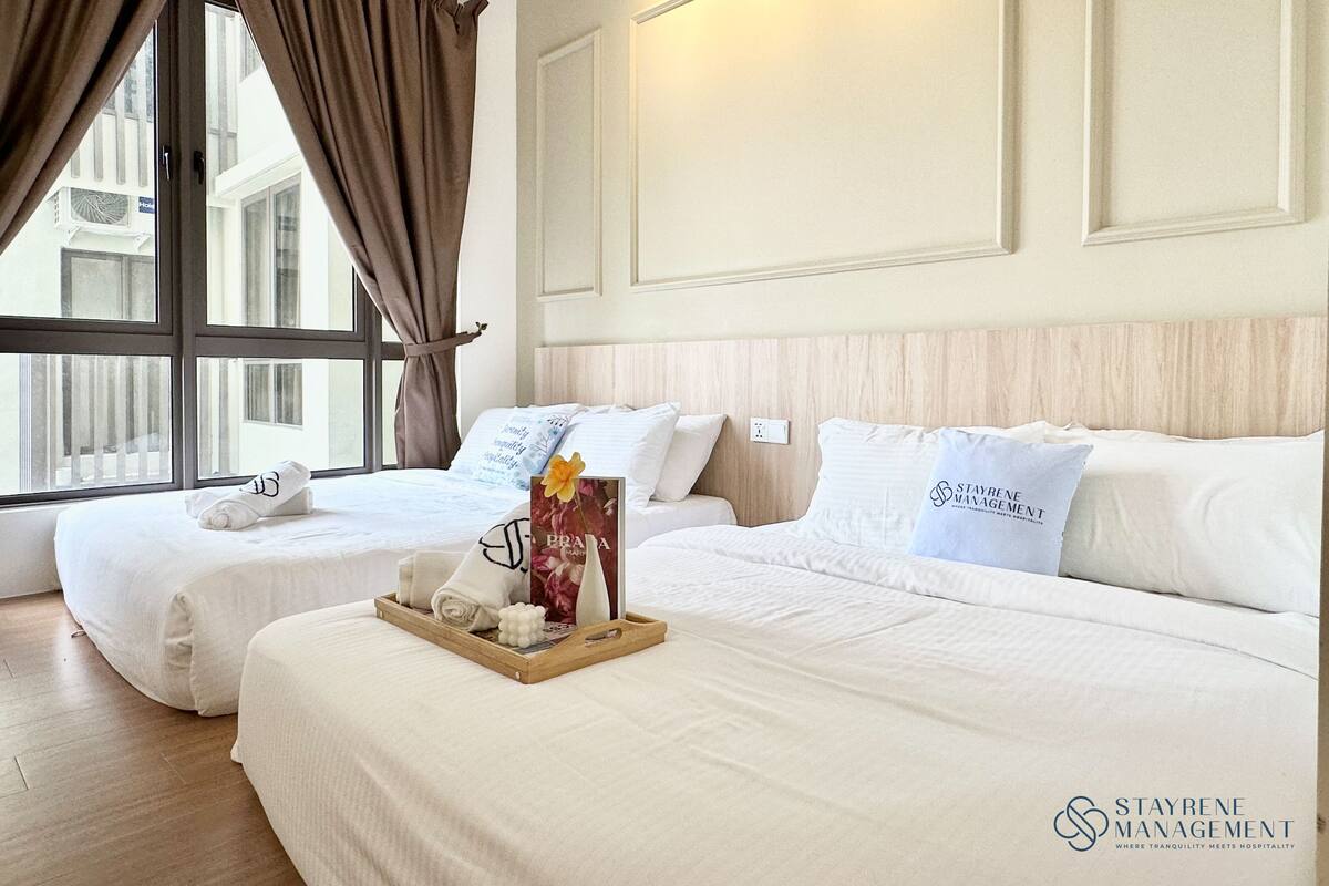 Une chambre d’hôtel avec deux lits, un plateau avec des articles de toilette et une vue sur l’extérieur.