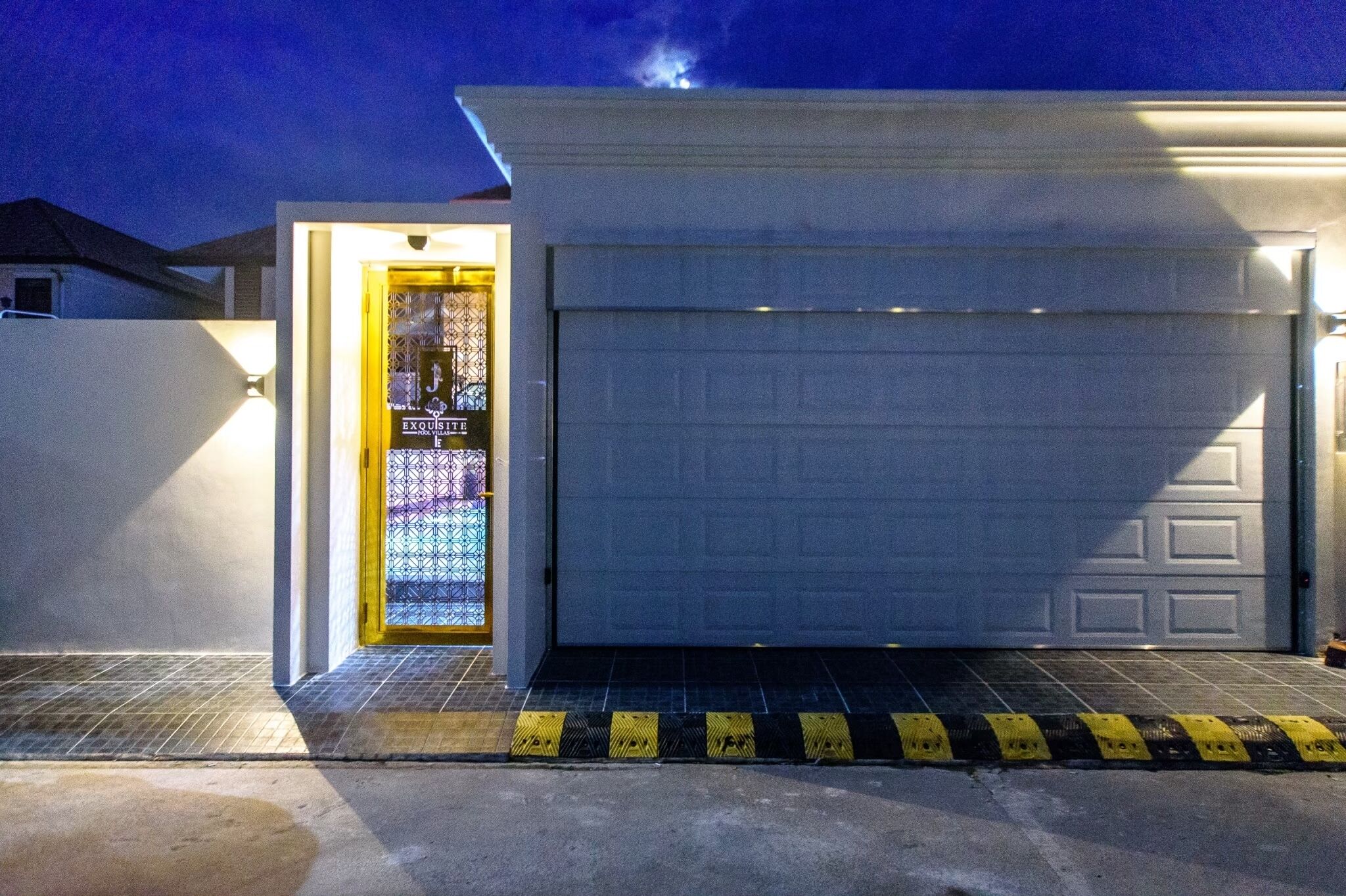 Un garage avec une porte blanche et une porte vitrée ornée d’un motif décoratif.
