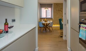A modern kitchen with a dining area, a stone wall, and a sign for Integral Finques.