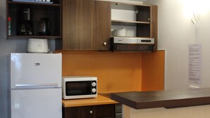 A compact kitchen with a refrigerator, microwave, and a coffee maker on the countertop. - Duplex T3 in Jausiers - 6 people, terrace, parking (Jausiers)