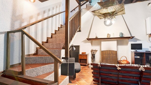 A staircase leading to a loft area with a wooden bench, a television, and a fireplace. - Apartment 'In Villa Belli' with Shared Garden & Wi-Fi (Miasino)