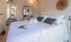 Ein Schlafzimmer mit einem großen Bett, einem Spiegel und einem Wanddekor.