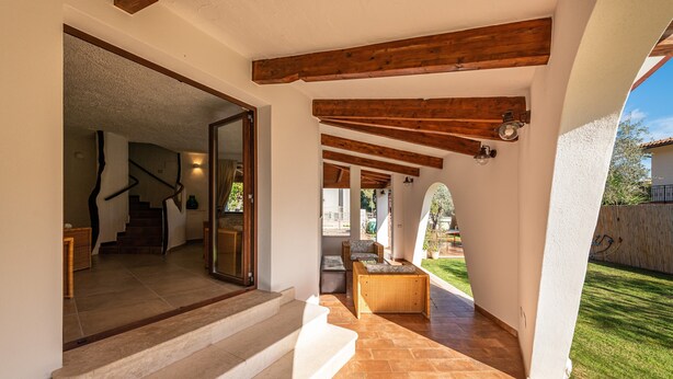 Un intérieur moderne avec un escalier menant à un deuxième étage, un plafond en bois et une vue sur un jardin.