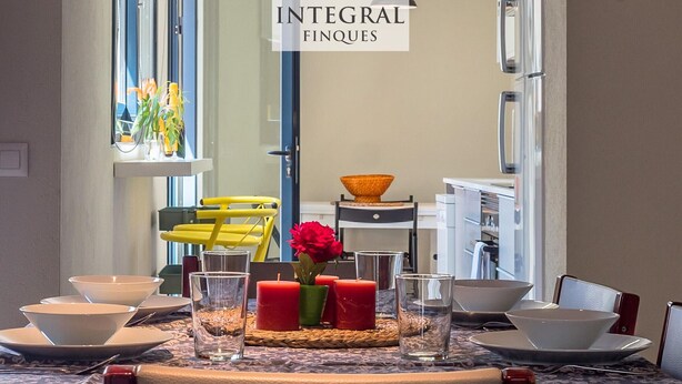 A dining area with a table set for four, including bowls, glasses, and a vase with flowers. - Beachfront Fisherman's Cottage with AC, Wi-Fi & Parking (Palamós)