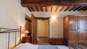 Ein Schlafzimmer mit einem Bett, einem Holzschrank und einem Nachttisch mit Lampe.