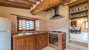Una cucina con mobili in legno, una finestra, un lavandino e un piano cottura.