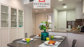 A modern dining area with a table set for breakfast, including croissants and juice. - Modern Apartment, 2 Bedrooms, 150m from Beach, Central Palamós, with Parking, WiFi & A/C (Palamós)