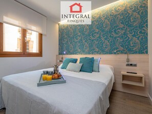 A hotel room with a bed, a tray with breakfast items, a patterned wall, and a window. - Modern Apartment, 2 Bedrooms, 150m from Beach, Central Palamós, with Parking, WiFi & A/C (Palamós)