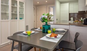A modern dining area with a table set for breakfast, including croissants and juice. - Modern Apartment, 2 Bedrooms, 150m from Beach, Central Palamós, with Parking, WiFi & A/C (Palamós)