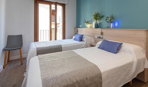 A hotel room with two beds, a chair, a window, and a wall with decorative plants. - Modern Apartment, 2 Bedrooms, 150m from Beach, Central Palamós, with Parking, WiFi & A/C (Palamós)