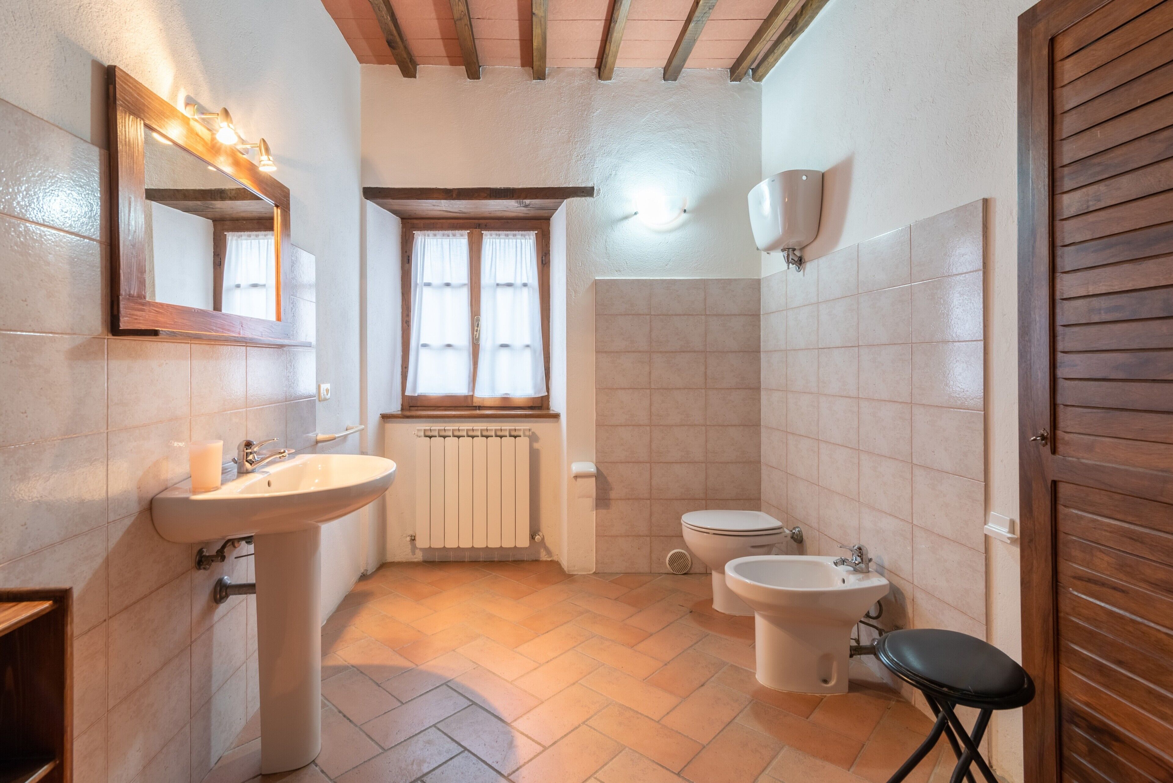 Une salle de bain équipée d’un lavabo, de toilettes, d’un bidet et d’un miroir.
