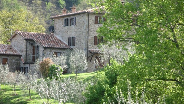A stone building with a tiled roof, surrounded by greenery and trees. - Agriturismo 'Cuiano La Loggetta' with Shared Pool, Garden and Wi-Fi (Cortona)