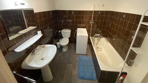 Une salle de bain avec un lavabo, des toilettes et une baignoire.