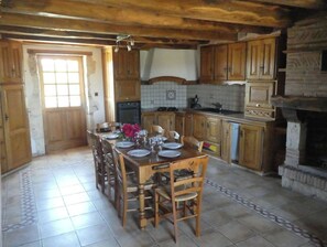 Enjoy meals in this cozy kitchen with a dining table, fireplace, and ample space to cook and socialize.