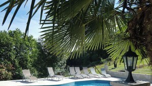 A swimming pool with lounge chairs and a lamp post.