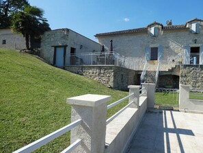 Traditional stone building with a rustic charm, featuring a steep hill and a clear path to the entrance.