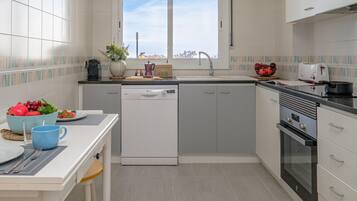 Una cocina moderna con lavavajillas, estufa y ventana con vistas a la ciudad.