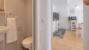 Une salle de bain équipée d’un lavabo, de toilettes et d’un porte-serviettes.