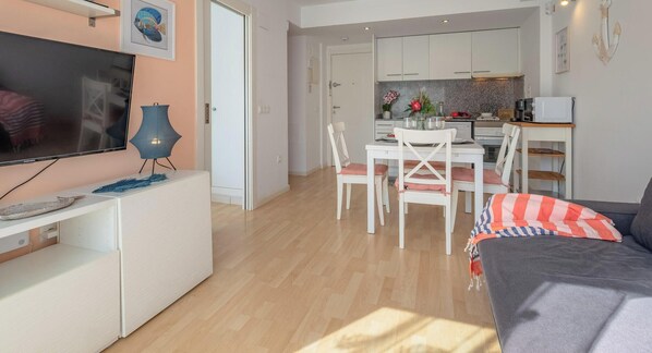 A modern living room with a flat-screen TV, a white entertainment unit, and a grey sofa. - Duplex Cosy à Palamós, à 200m de la Plage, Parking, WiFi, Climatisation (Palamós)
