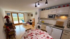A compact kitchen with a dining area, a washing machine, and a microwave.