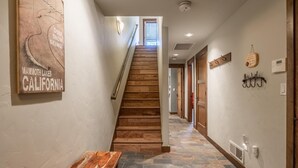 Un couloir avec un escalier en bois, un banc et une plaque fixée au mur sur laquelle on peut lire : « Mammoth Lakes, Californie ».