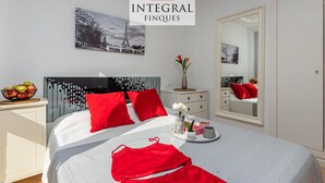 A hotel room with a bed, a nightstand, a mirror, and a wall with a picture of the Eiffel Tower. - Stunning Duplex 200m from Platja Gran, 3BR, Balcony, Terrace, Parking, WiFi, A/C, Lift (Palamós)
