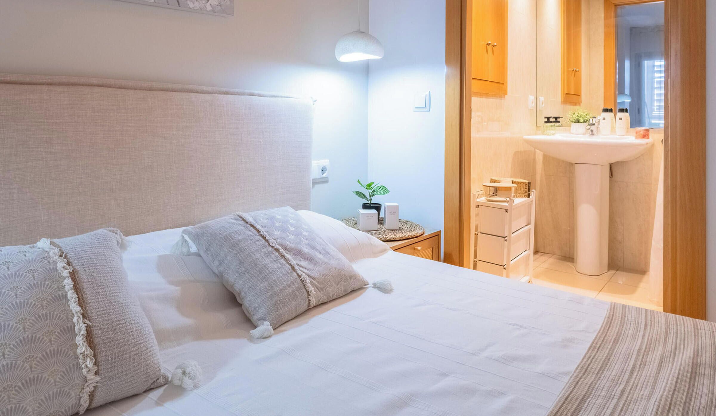 Une chambre d’hôtel avec un lit, une table de chevet, une lampe et une vue sur la salle de bain.