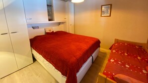Un dormitorio con cama, cabecero de madera, mesita de noche y armario.