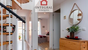 A modern interior with a staircase, a wooden cabinet, and a mirror on the wall. - Duplex Cosy avec Grande Terrasse à 50m de la Plage de Palamós (Palamós)
