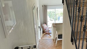 Un escalier menant à une pièce dotée d’une fenêtre, d’une chaise et d’un bureau.