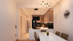 Eine moderne Küche mit einer zentralen Kochinsel, Holzschränken und einem eingebauten Backofen.