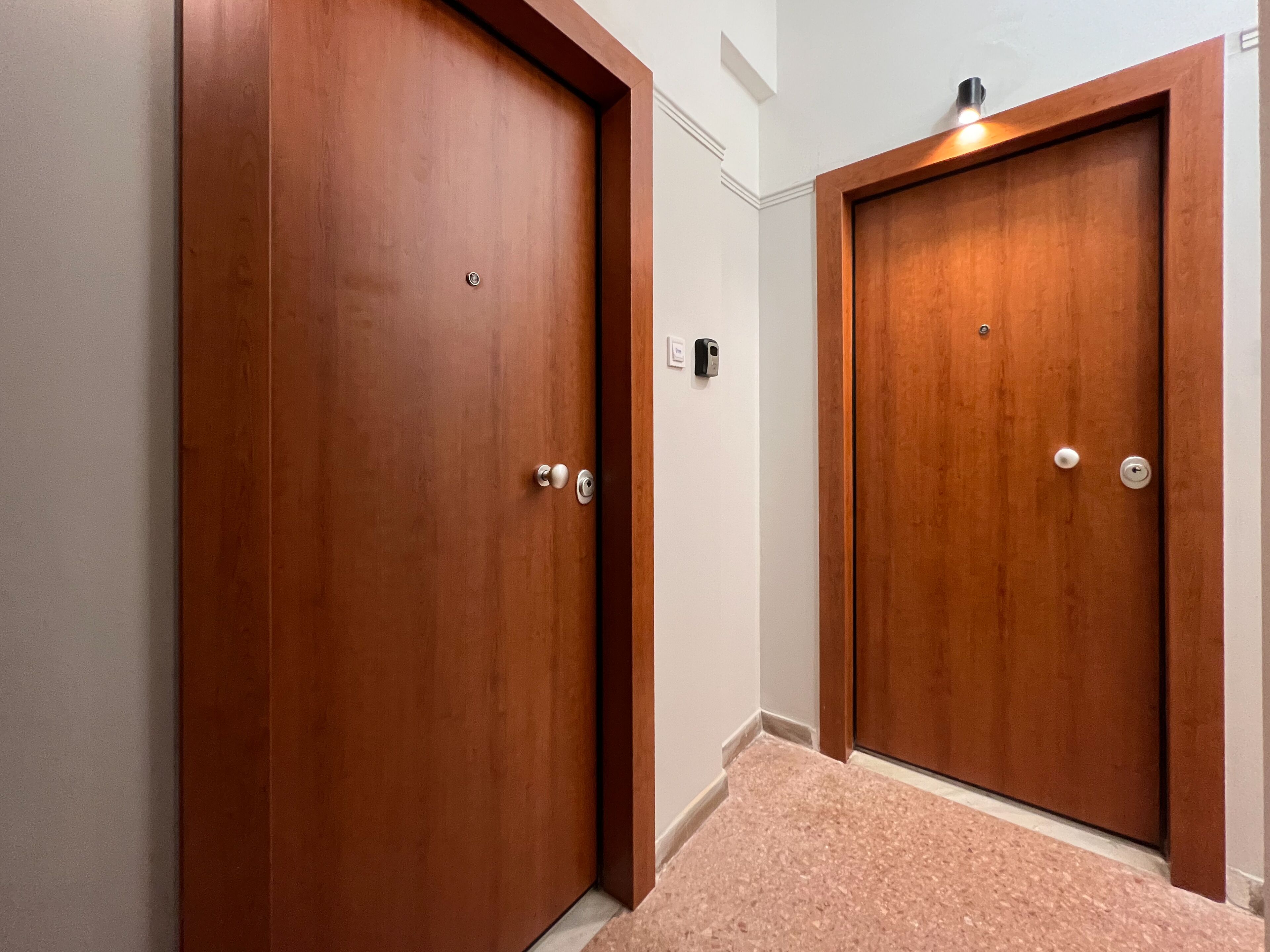 Two wooden doors with a keyhole and a lock, a small light above the right door, and a carpeted floor.