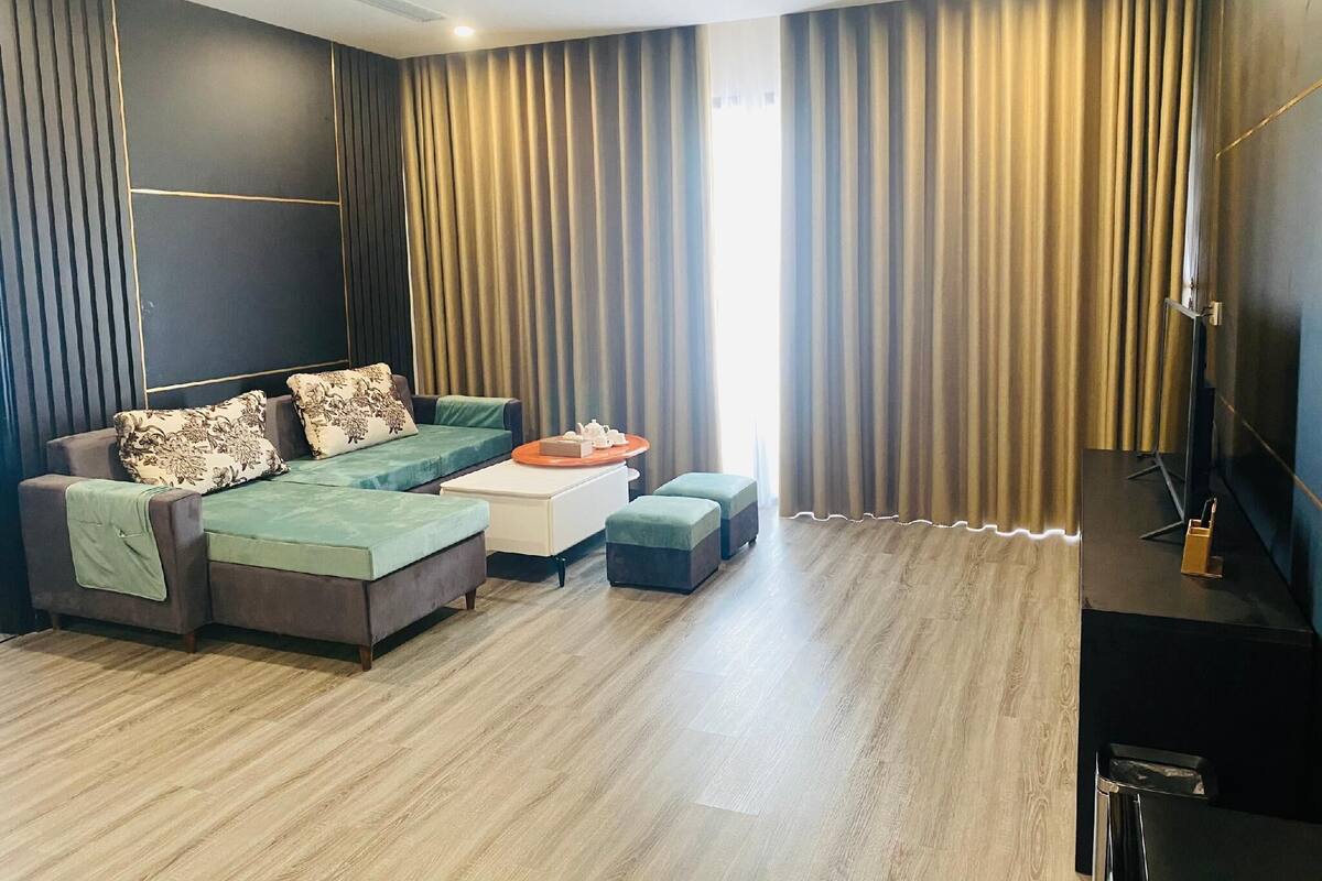 Una sala de estar moderna con un sofá seccional, una mesa de centro y un televisor de pantalla plana.