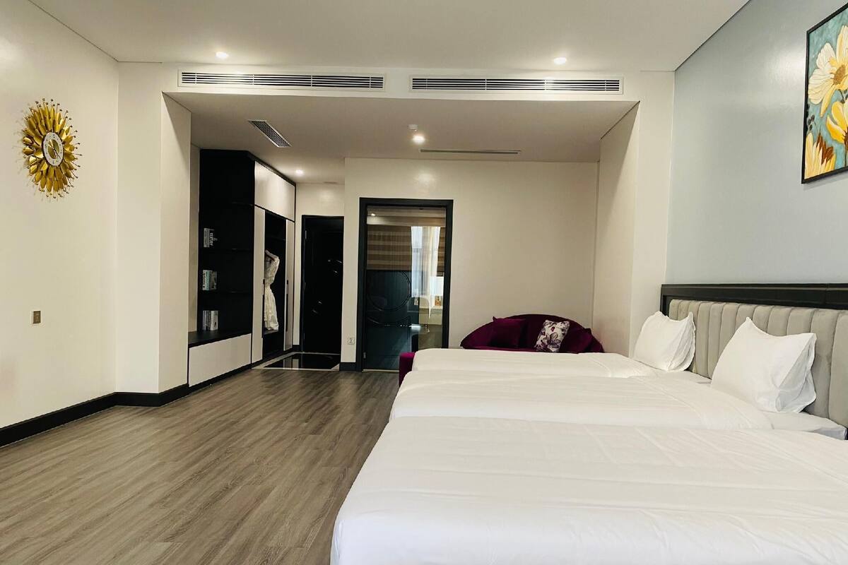 Habitación de hotel con una cama grande, un armario, un espejo y un cuadro en la pared.