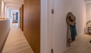 A hallway with a wooden partition, a door, and a hat hanging on the wall.