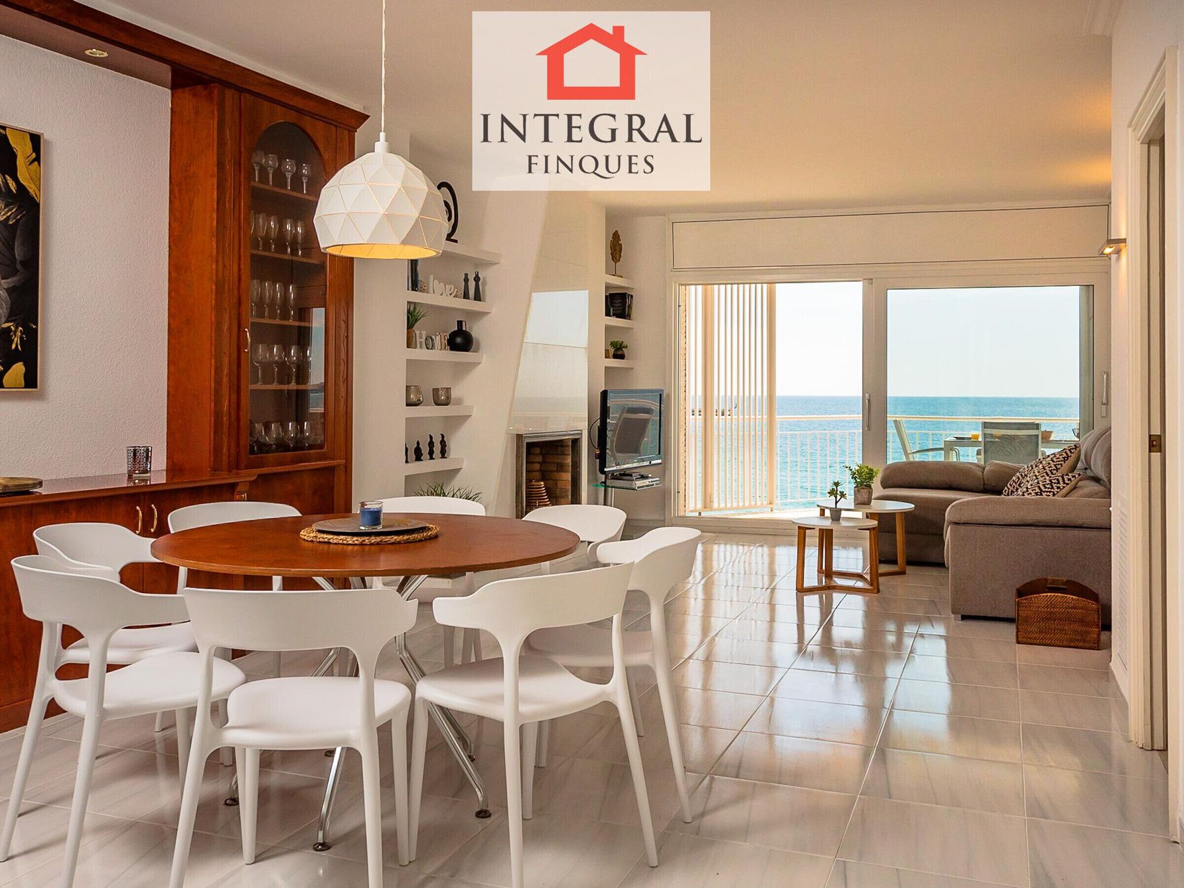 Un salon moderne avec un coin repas, une cheminée et une vue sur la mer.
