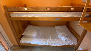 A bunk bed with two levels, each with a mattress and pillows. - 18m² Studio near slopes, balcony, parking (La Chapelle-d'Abondance)