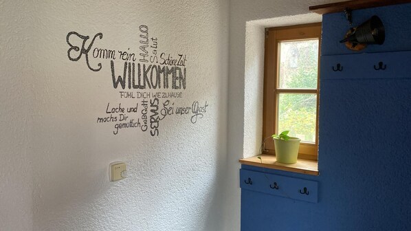 Une pièce dont un mur est décoré d’un message de bienvenue écrit en allemand.