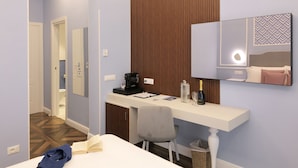 Une chambre d’hôtel équipée d’un bureau, d’une chaise, d’un lit, d’un miroir et d’un mur recouvert de panneaux de bois.