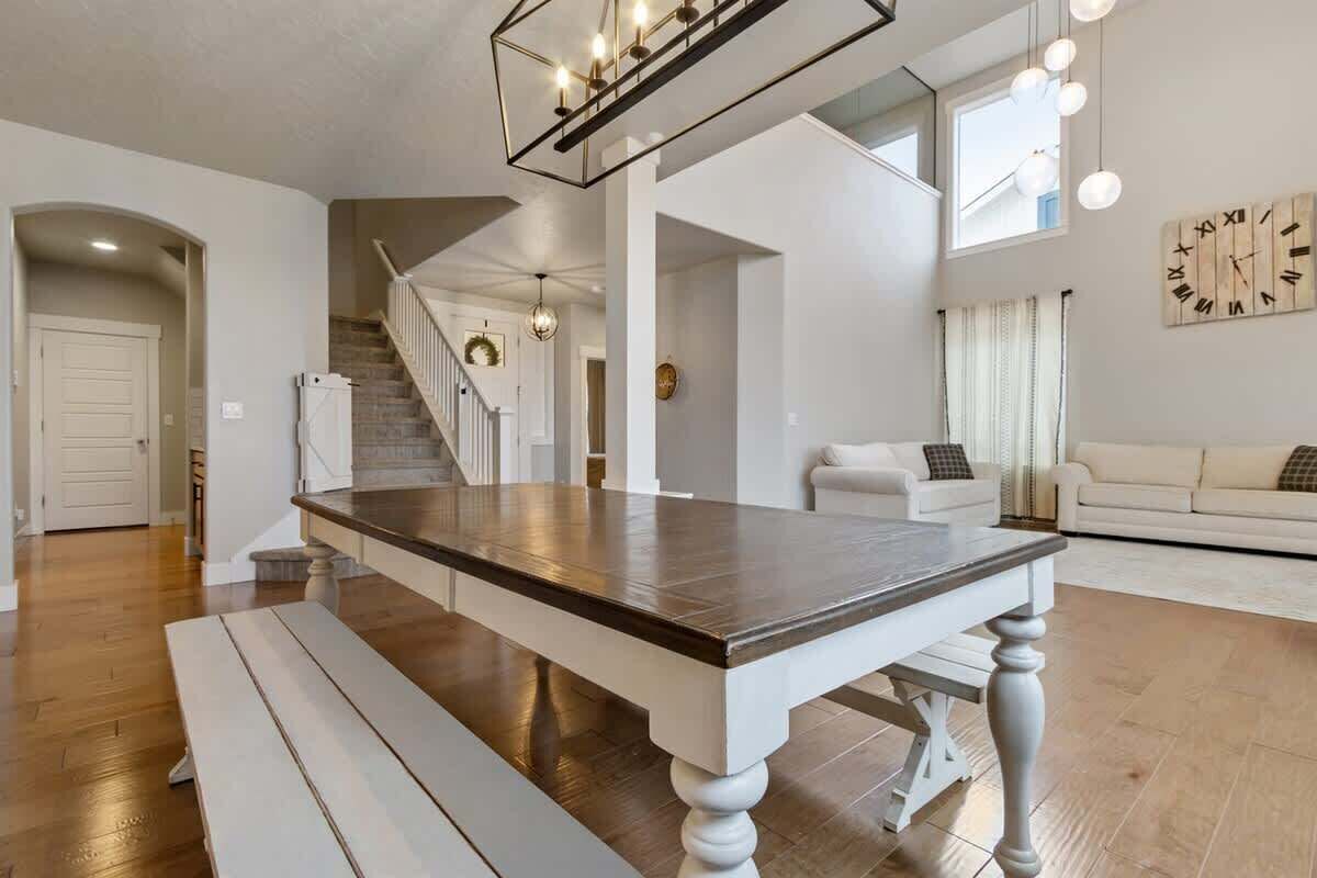 A spacious living area with a dining table, a staircase, and a sofa.