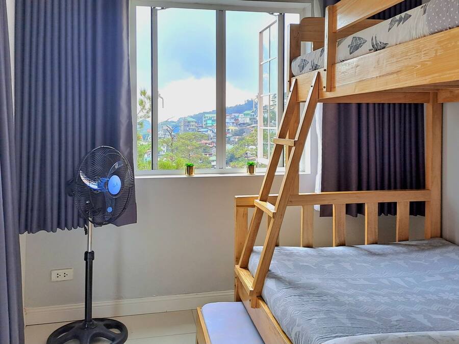 Una cama litera con vistas a un paisaje urbano a través de una ventana.