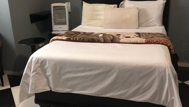 Une chambre d’hôtel avec un lit, une télévision et une petite table.
