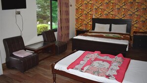 A bedroom with a bed, a desk, a chair, a TV, and a window with curtains. - Ever Green Hotel & Restaurant (Balakot)