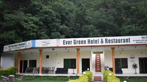 The exterior of Ever Green Hotel & Restaurant with a covered front porch, outdoor seating, and a well-maintained garden. - Ever Green Hotel & Restaurant (Balakot)