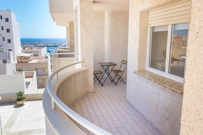 A balcony with a table and chairs, overlooking a cityscape and the sea. - Costa de Almeria, GarruchaPueblo, Costa de Almeria, Garrucha Pueblo (Garrucha)